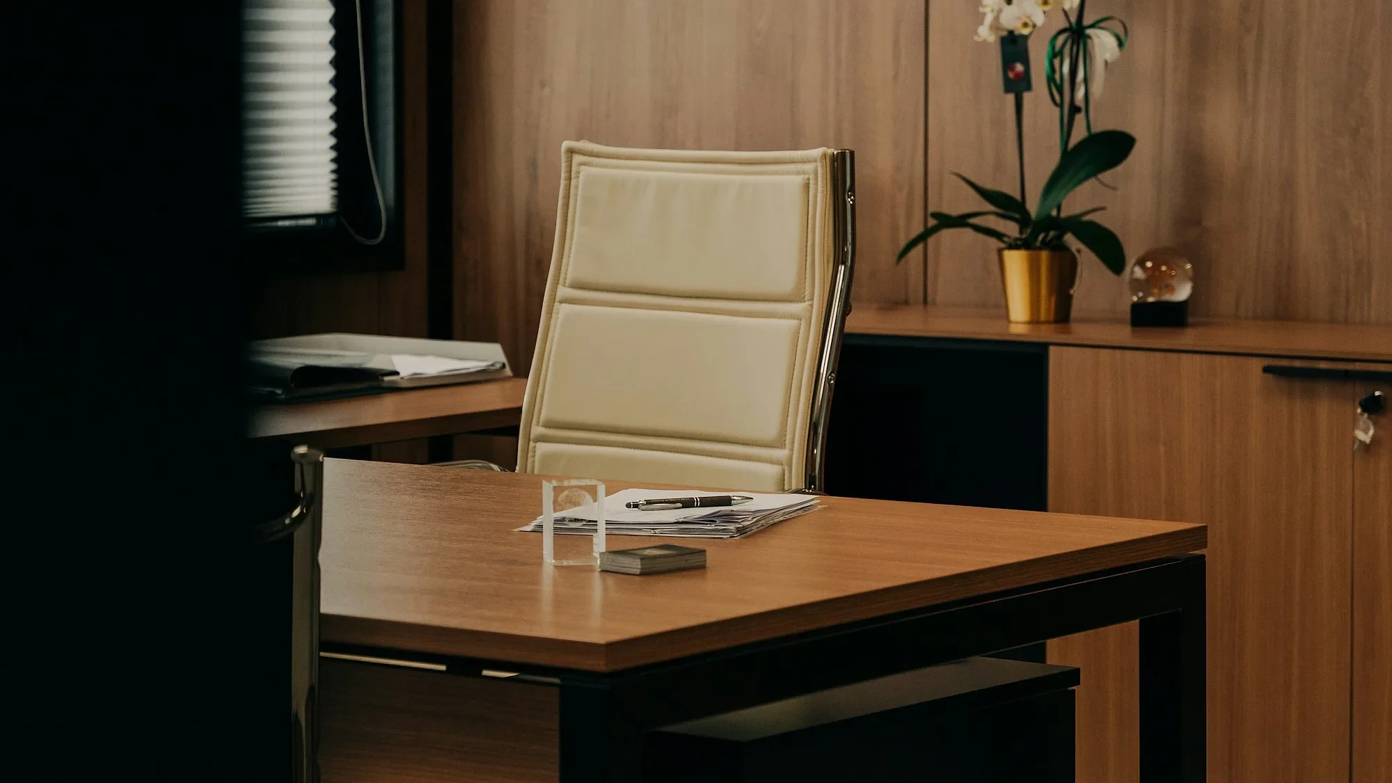 Escritorio de oficina en madera con silla y paneles de madera al fondo
